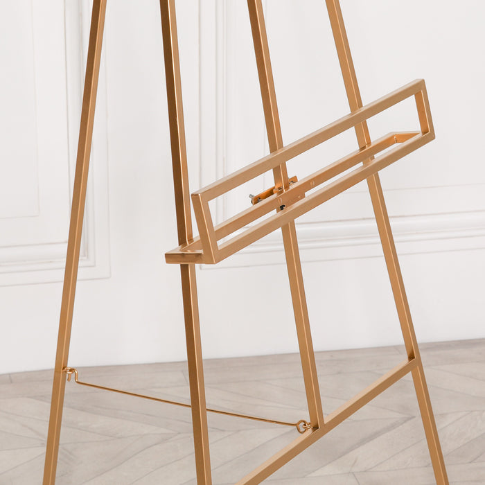 Close-up of adjustable shelf on bright gold metal easel with minimalist details

