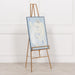 Adjustable bright gold metal easel holding framed artwork in gallery setting

