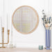 Stylish round gold mirror with wooden frame above a modern living room console table

