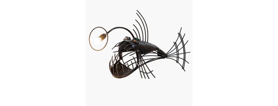 Handmade anglerfish table lamp crafted from reclaimed metal and car parts in steampunk industrial style – Quirky Barn lighting design.
